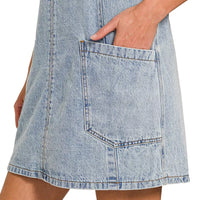 Light wash denim overall dress with large front patch pocket and contrast stitching