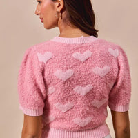 Back view: pink cropped heart-print knit sweater with crew neck, short sleeves