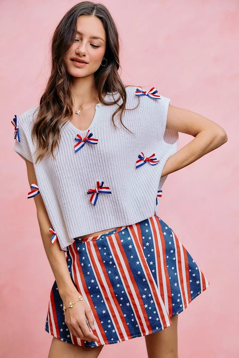 Off-white dolman sweater top with red, white, and blue ribbon bow accents