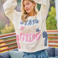 Cream sweatshirt with red bow patch and blue star patches with stars-and-stripes