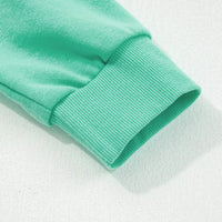 Turquoise sweatshirt sleeve cuff and hem close-up with ribbed trim
