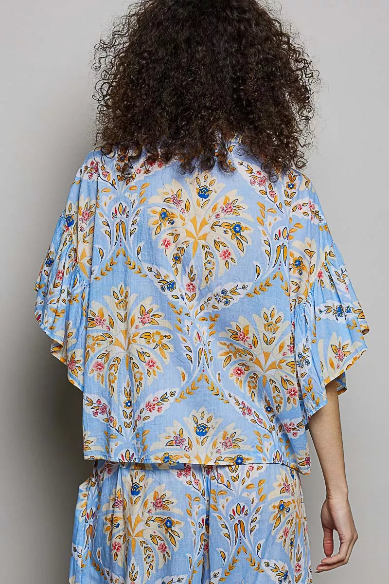 Blue floral printed woven shirt with ruffle sleeves and elastic waist, back view