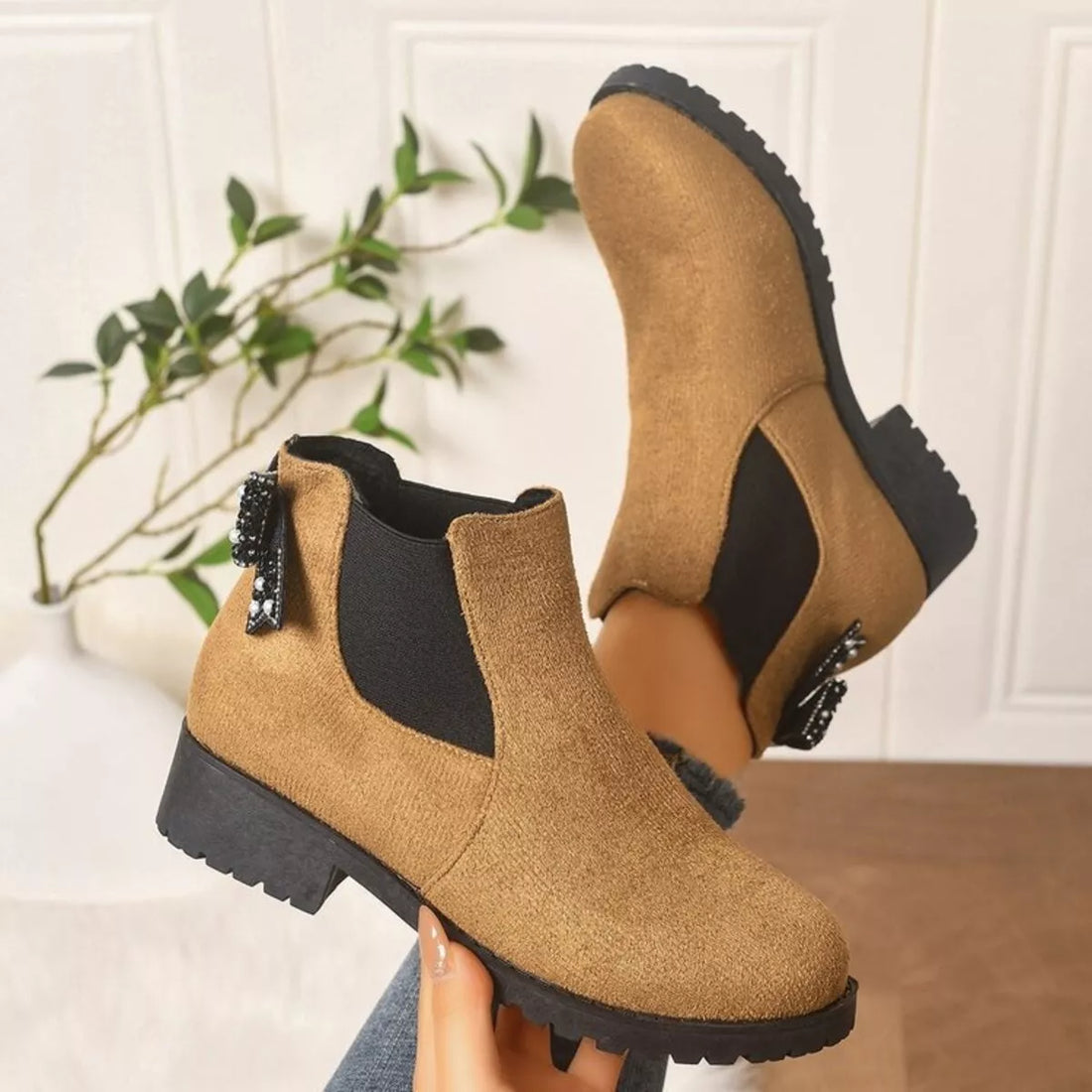 Tan suede ankle boots with round toe, block heel, and jeweled bow ankle detail