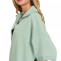 Dusty green short-sleeve collared pullover, side view with draped shoulder