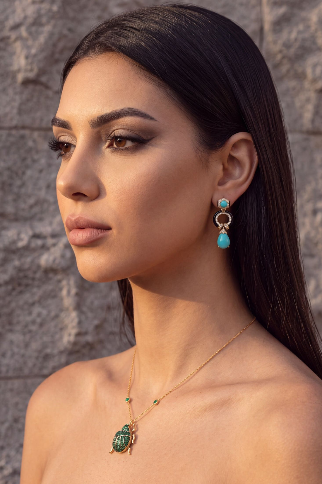 Green scarab pendant necklace with gold chain shown on a model’s neckline