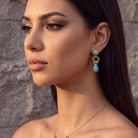 Green scarab pendant necklace with gold chain shown on a model’s neckline