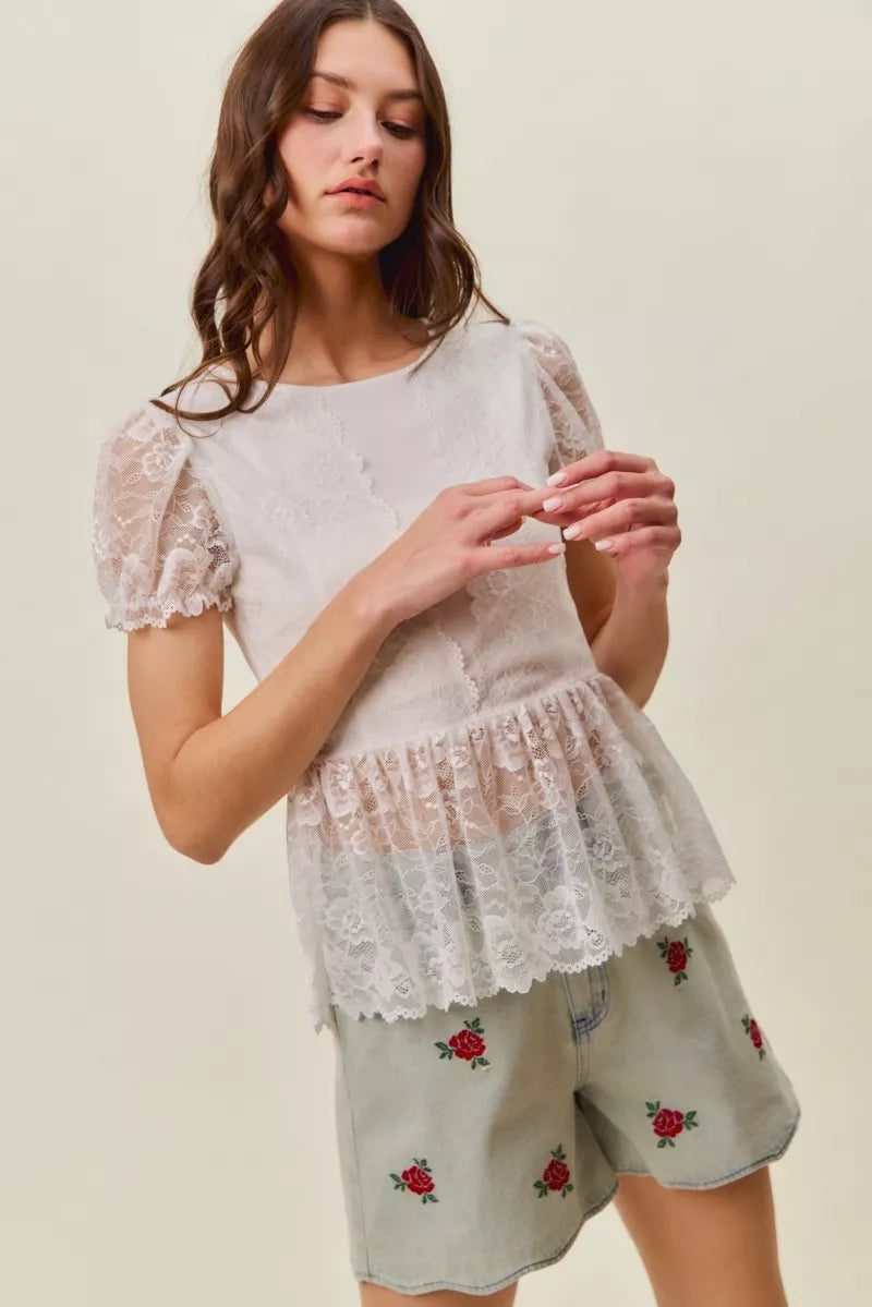 Model wearing light-wash denim shorts with rose embroidery