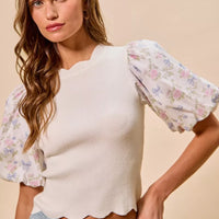 White rib knit top with floral puff sleeves; scalloped hem and crew neckline