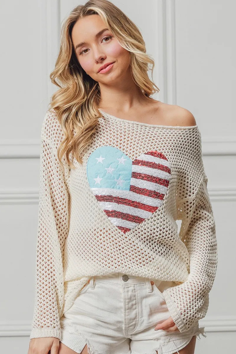Off-white knit sweater with American flag heart sequin patch, wide neckline.