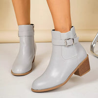 Light gray point-toe block heel ankle boots with buckle strap and stitched seam