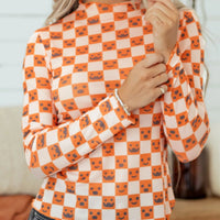 Halloween long sleeve mock neck blouse with orange-and-white checker pattern and jack-o’-lantern faces