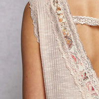 Pale pink sleeveless top close-up: lace-trim panel with floral embroidery edging