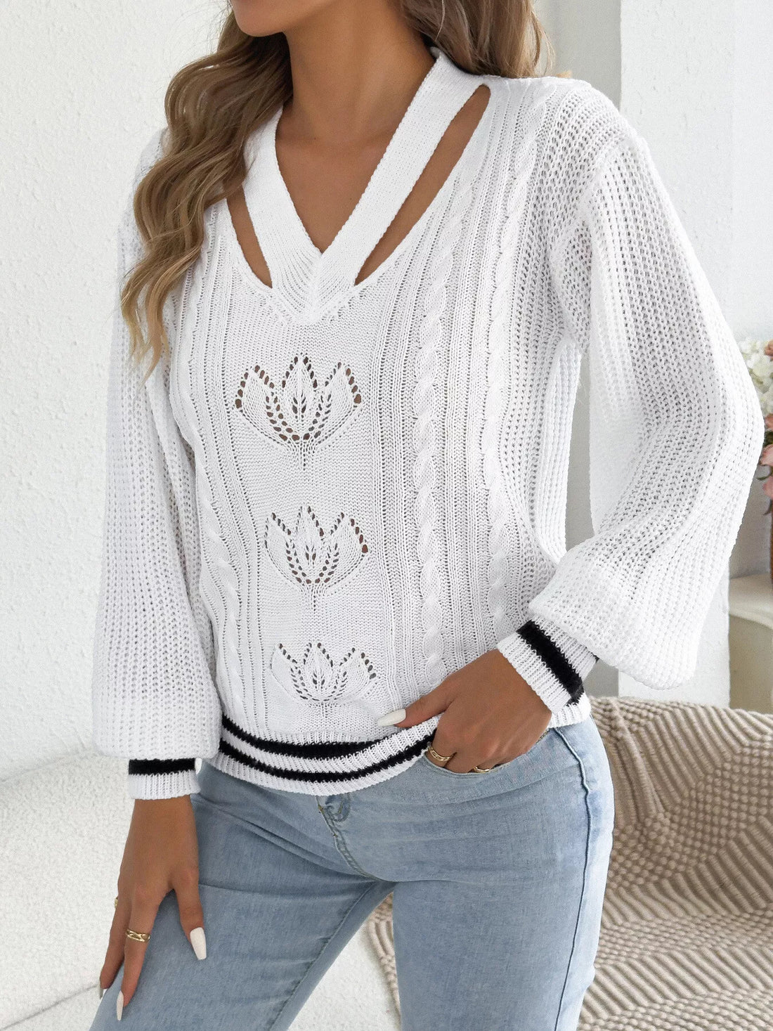 White cutout cable knit sweater with ribbed V-neck and striped cuffs
