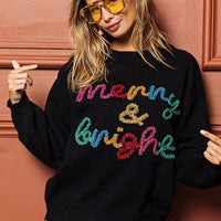 Black Christmas sweater with multicolor "Merry & Bright" sparkle lettering and long sleeves
