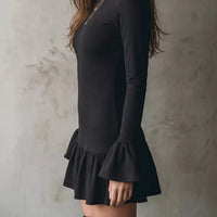 Black long-sleeve mini dress with ruffle hem detail and flared sleeve cuffs