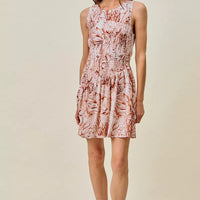 Full front view of coral and white shell-print sleeveless mini dress with smocked bodice