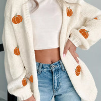 White knit cardigan with pumpkin embroidery, open front, long sleeves and ribbed cuffs.