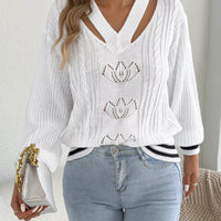 White cutout cable knit sweater with V-neck cutout and three lotus-style knit motifs