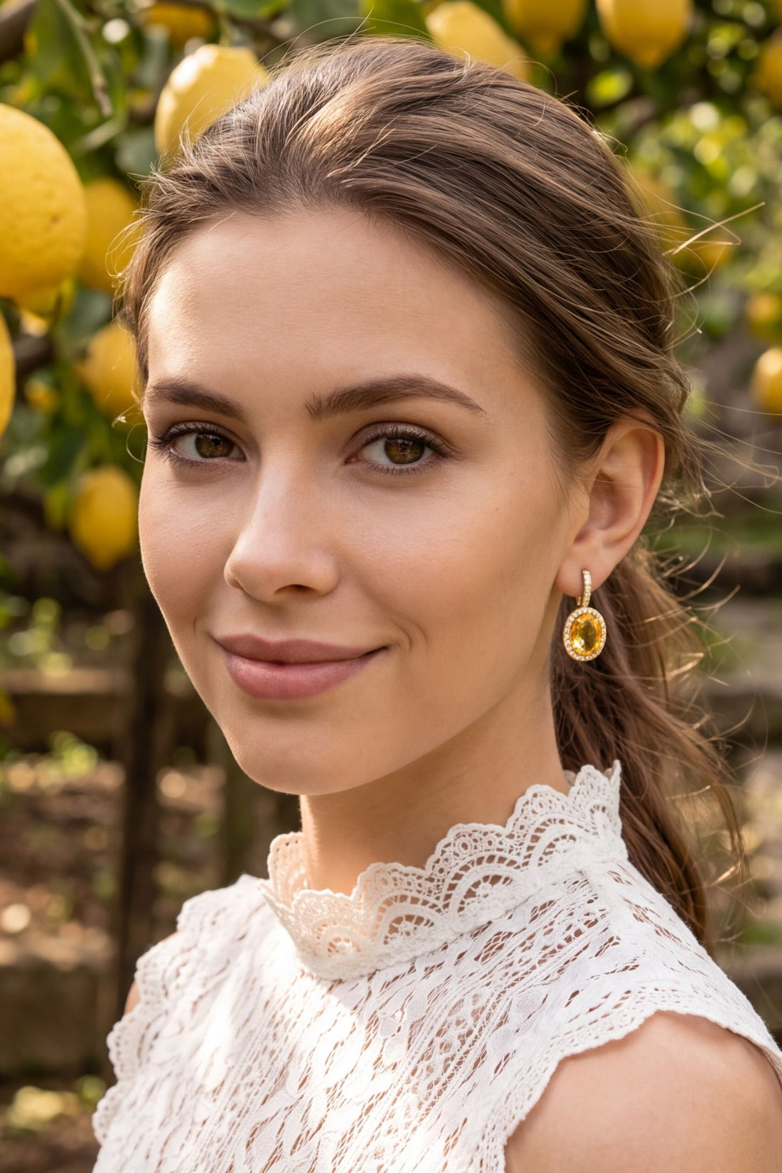 Gold citrine oval drop earrings with crystal halo on model
