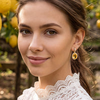 Gold citrine oval drop earrings with crystal halo on model