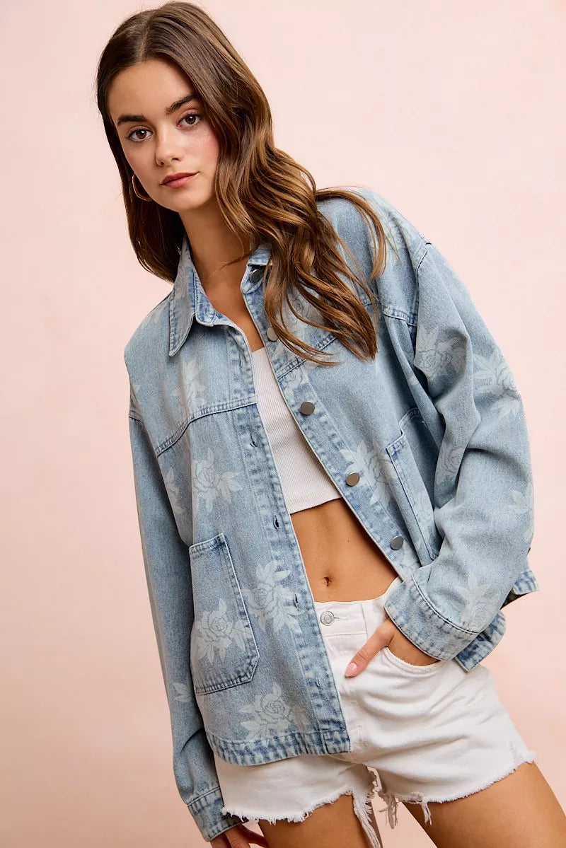 Light blue denim jacket with white floral print and button front, worn over a white top