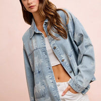 Light blue denim jacket with white floral print and button front, worn over a white top