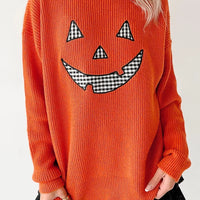 Orange knit long-sleeve sweater with jack-o-lantern face and round neckline