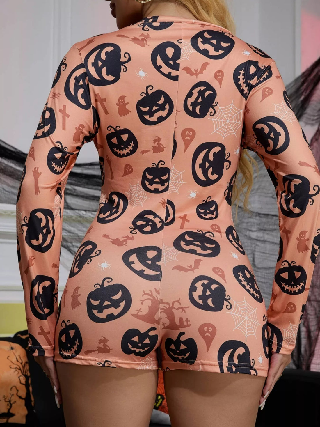 Dusty pink back view lounge romper with long sleeves and repeating jack-o-lantern print