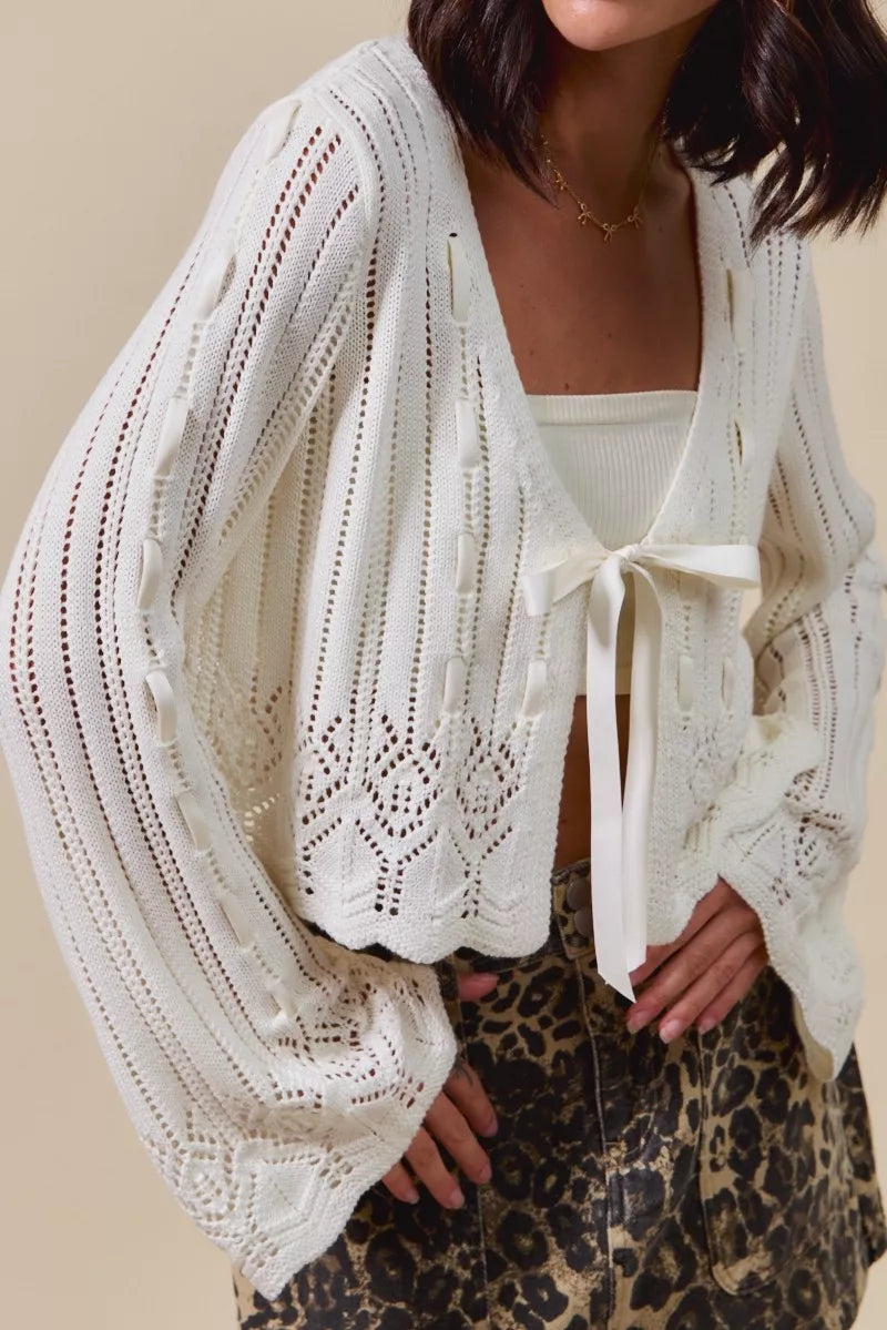 Off-white textured knit cardigan close-up, open front and ribbon bow detail
