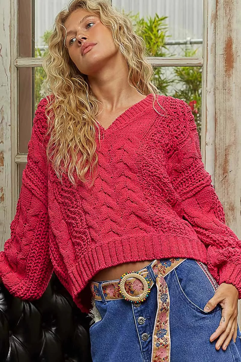 Fuchsia cable-knit cropped V-neck sweater with long puff sleeves and ribbed neckline