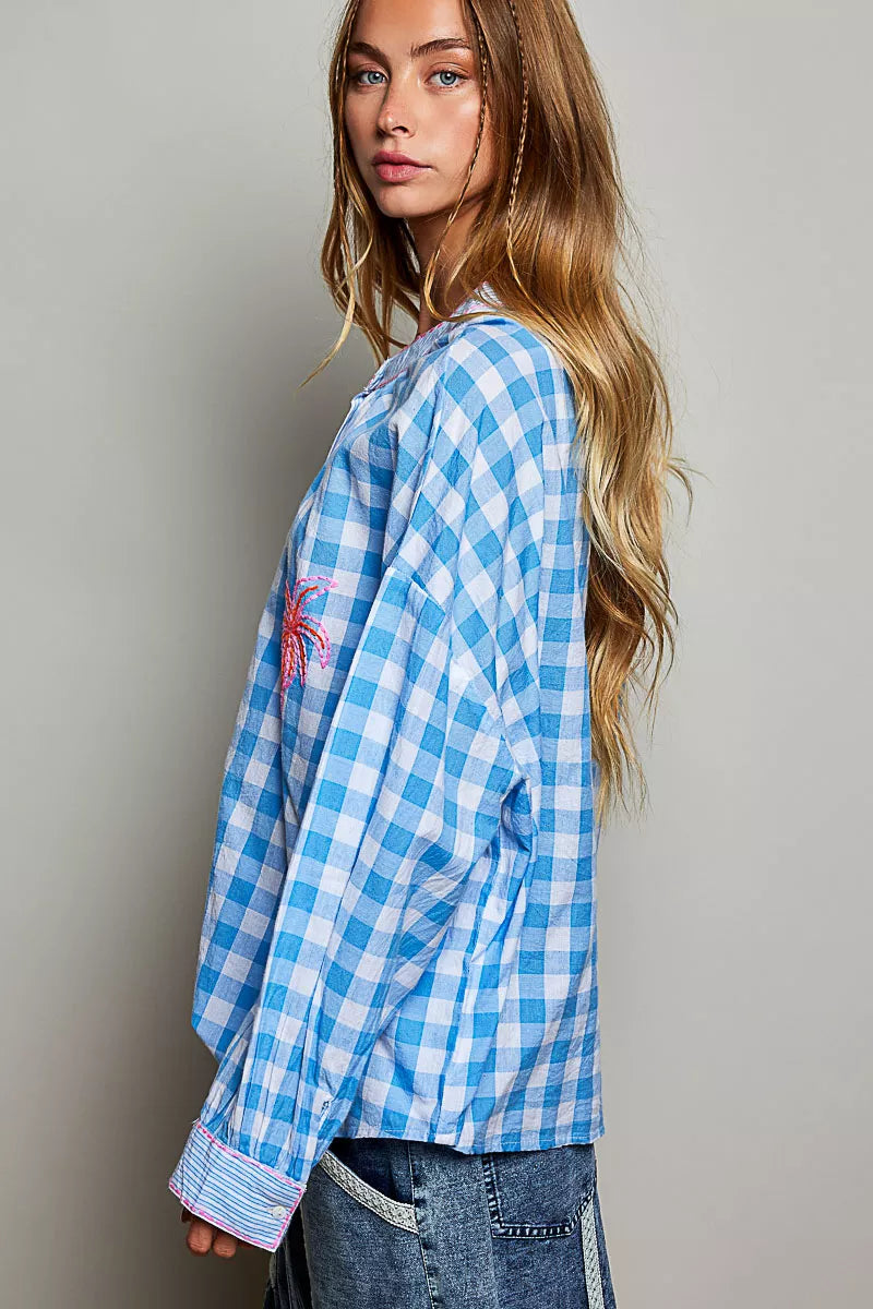 Blue gingham blouse with embroidered palm detail and ruffled neckline, long sleeves