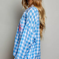 Blue gingham blouse with embroidered palm detail and ruffled neckline, long sleeves