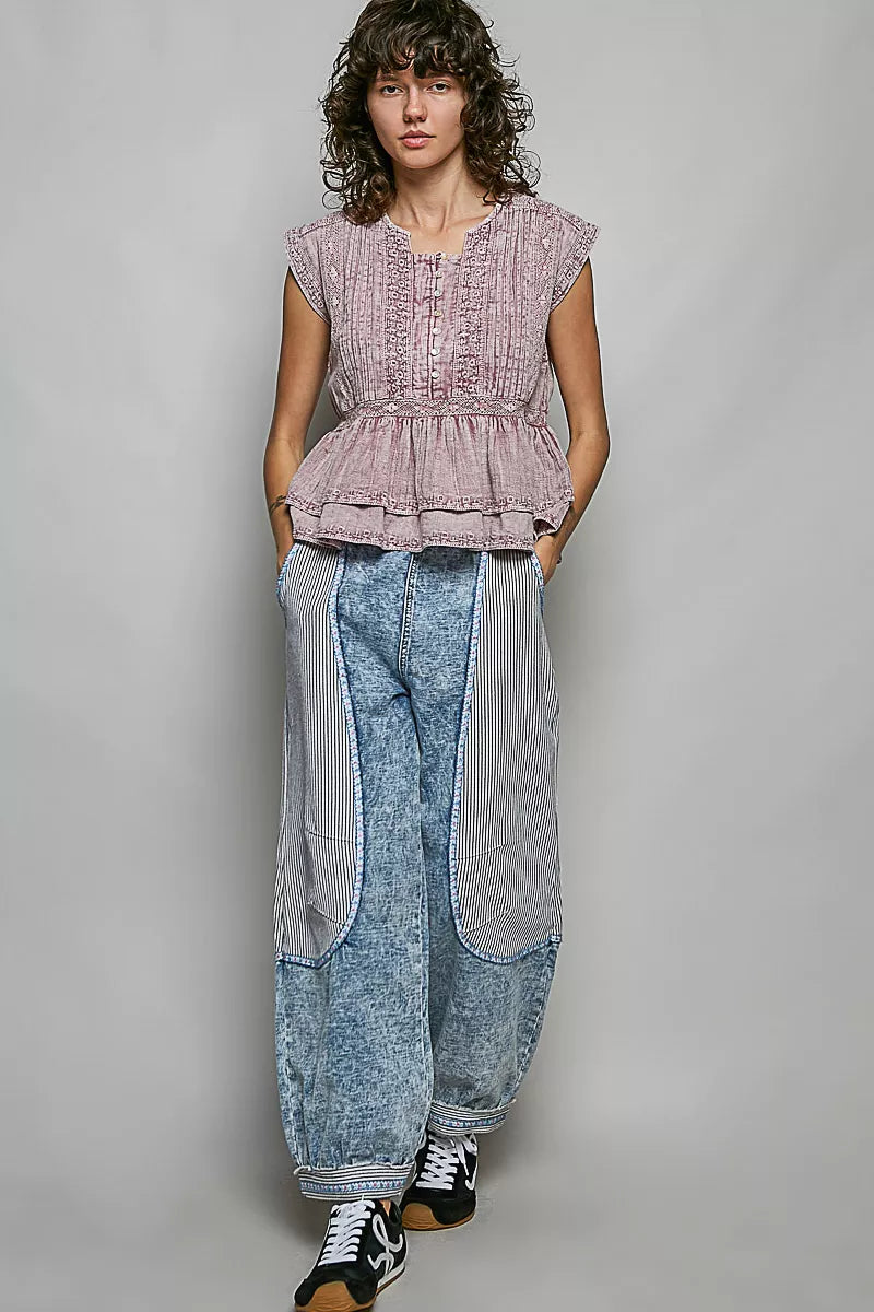 Pink sleeveless embroidered peplum blouse with pintuck front, gathered waist, and ruffle hem.