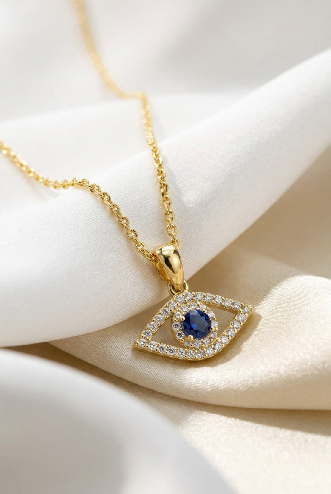 Gold evil eye elliptical necklace with blue stone pendant
