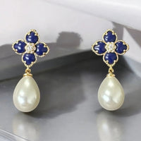 Gold-tone clover flower drop earrings with navy enamel petals and white pearl dangles