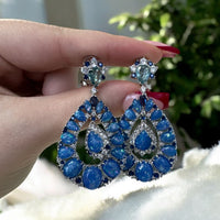 Blue teardrop drop earrings with clustered round stones on silver settings