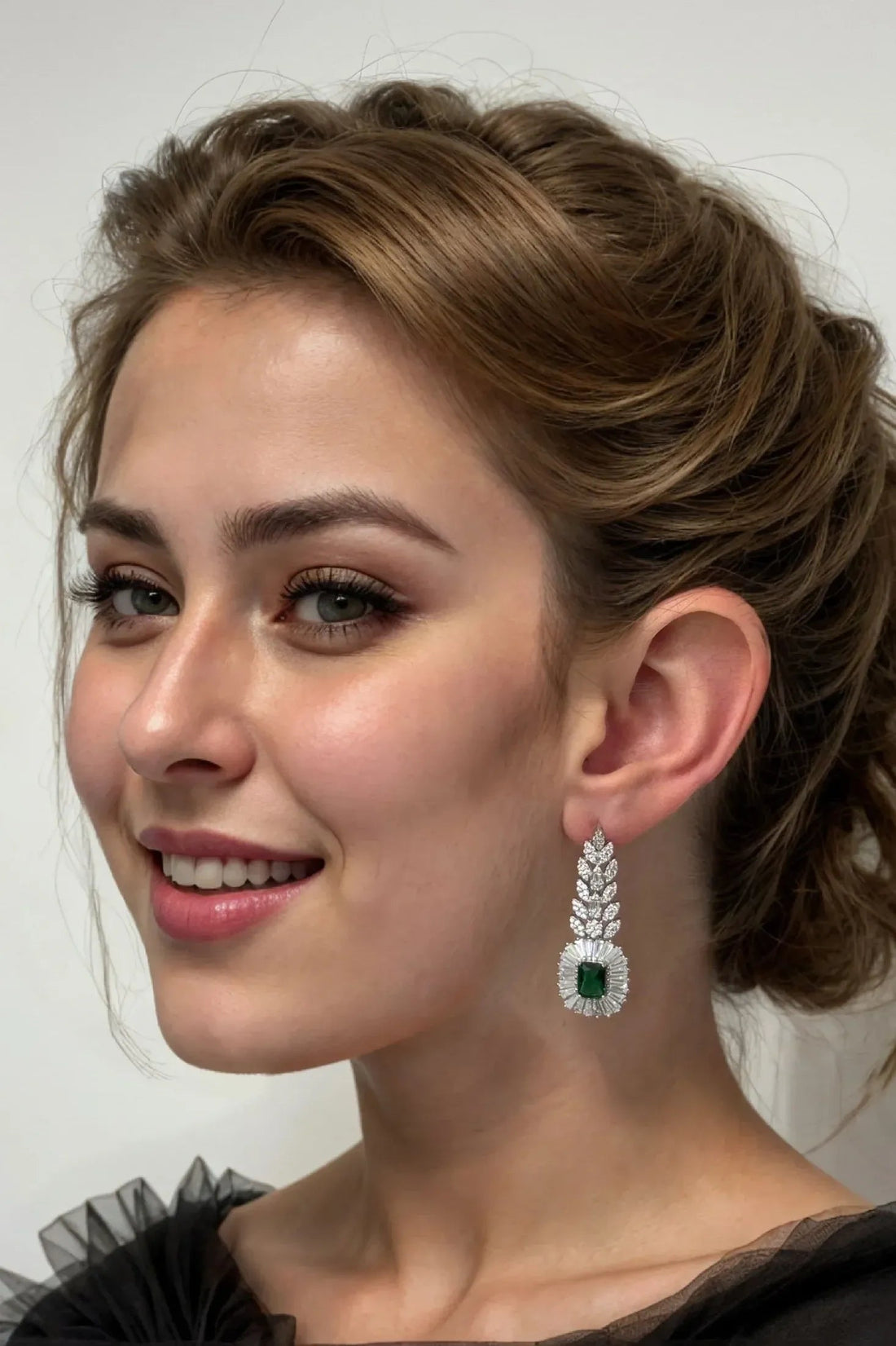Silver drop earring with emerald center and clear stones