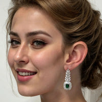 Silver drop earring with emerald center and clear stones