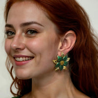 Green flower stud earrings on model ear, gold petals with yellow center