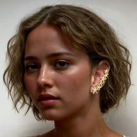 Gold starfish ear climber earring with stacked star shapes on left ear