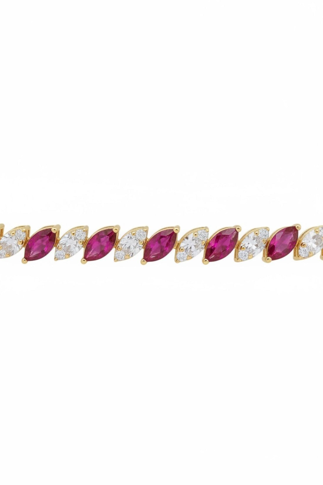 Close-up gold bracelet row with oval ruby-red stones and clear accents