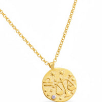 Gold zodiac talisman necklace with round Libra pendant and blue crystal, pendant close-up