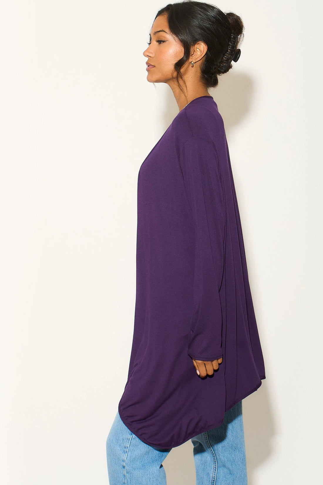 Purple waterfall cardigan, side view with long draped hem over jeans