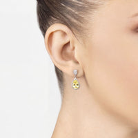 Yellow topaz drop earring in silver, shown on a model's ear