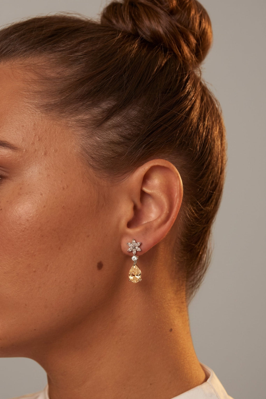 Silver stud-to-drop earrings with crystal flower tops and yellow dangling teardrops