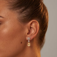 Silver stud-to-drop earrings with crystal flower tops and yellow dangling teardrops
