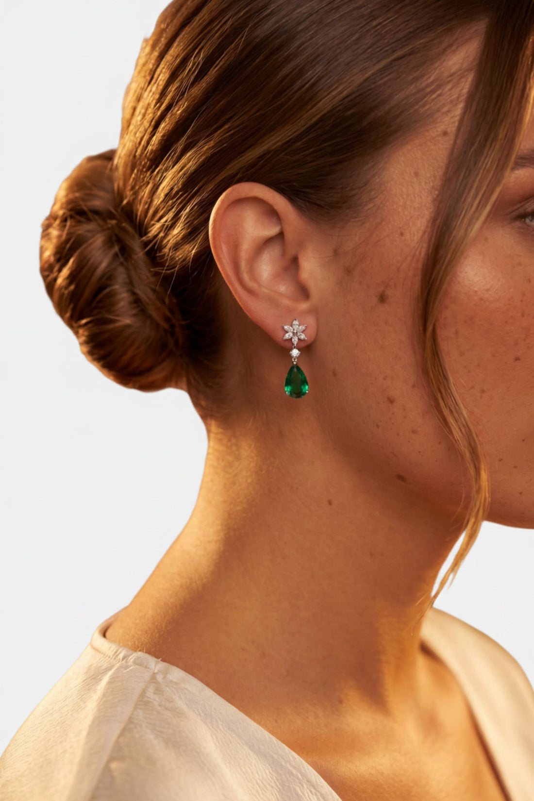 Silver earrings with crystal flower studs and emerald-green teardrop dangles