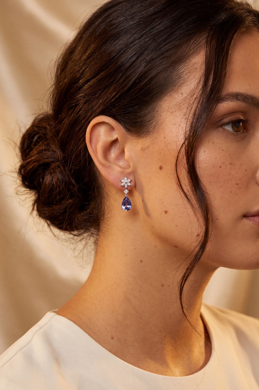 Silver drop earrings on model with crystal starburst and deep blue teardrop stones