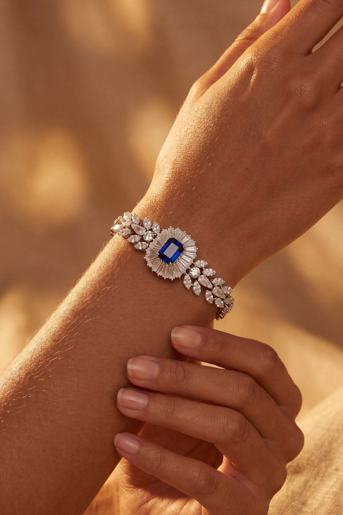 Silver gemstone bracelet on wrist with blue sapphire centerpiece
