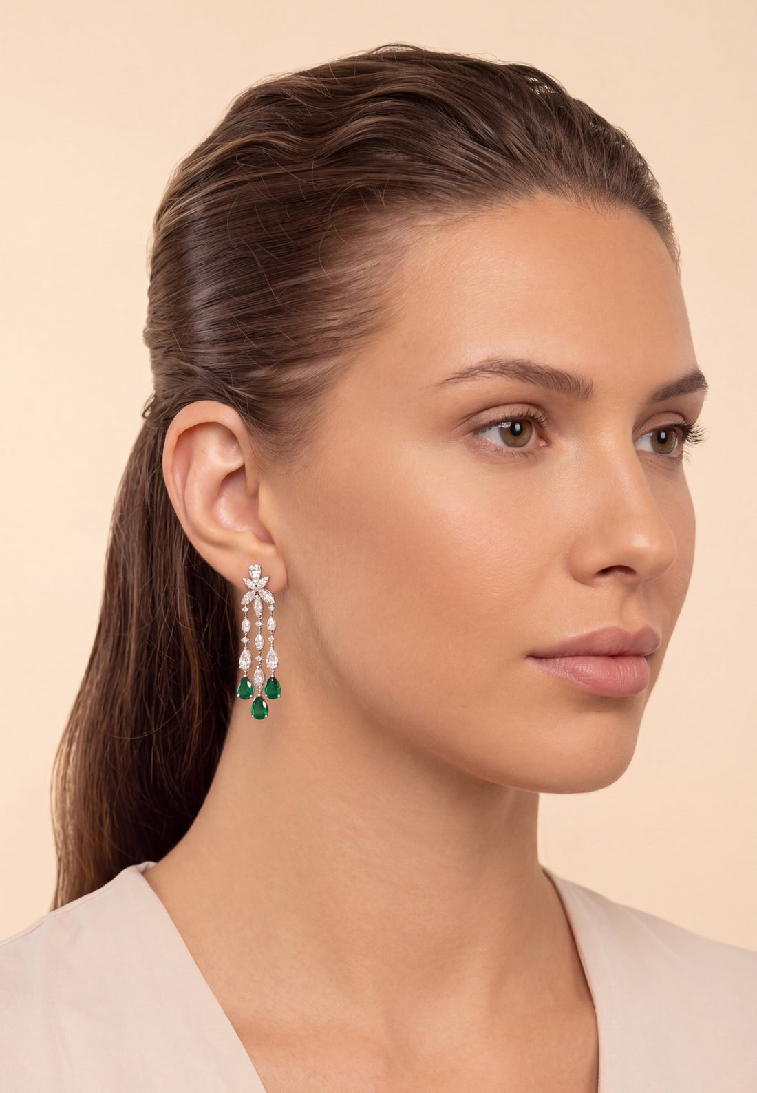 Silver drop earrings with green teardrop stones and dangling crystal-like accents